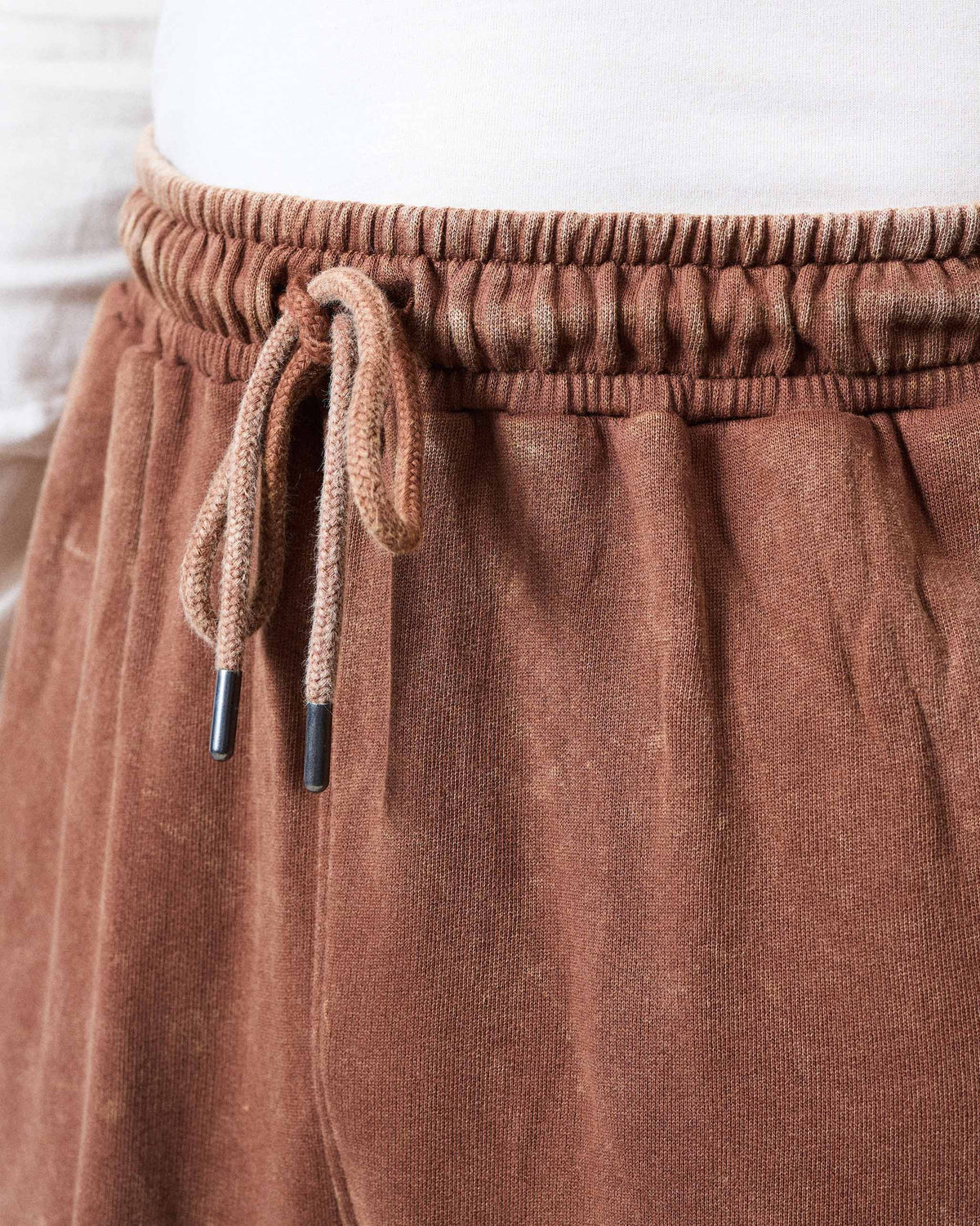 Close-up of the brown Drift bottoms drawstring waist with black tips.