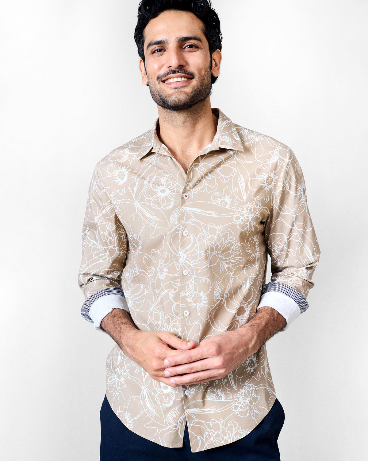 Person wearing a light brown Hakuna Shirt with a white floral print.