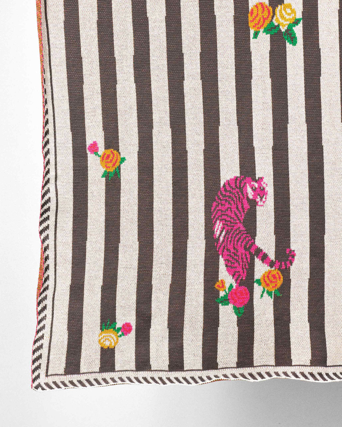 Close-up of the Ara Throw showing a pink tiger among rose sprigs.