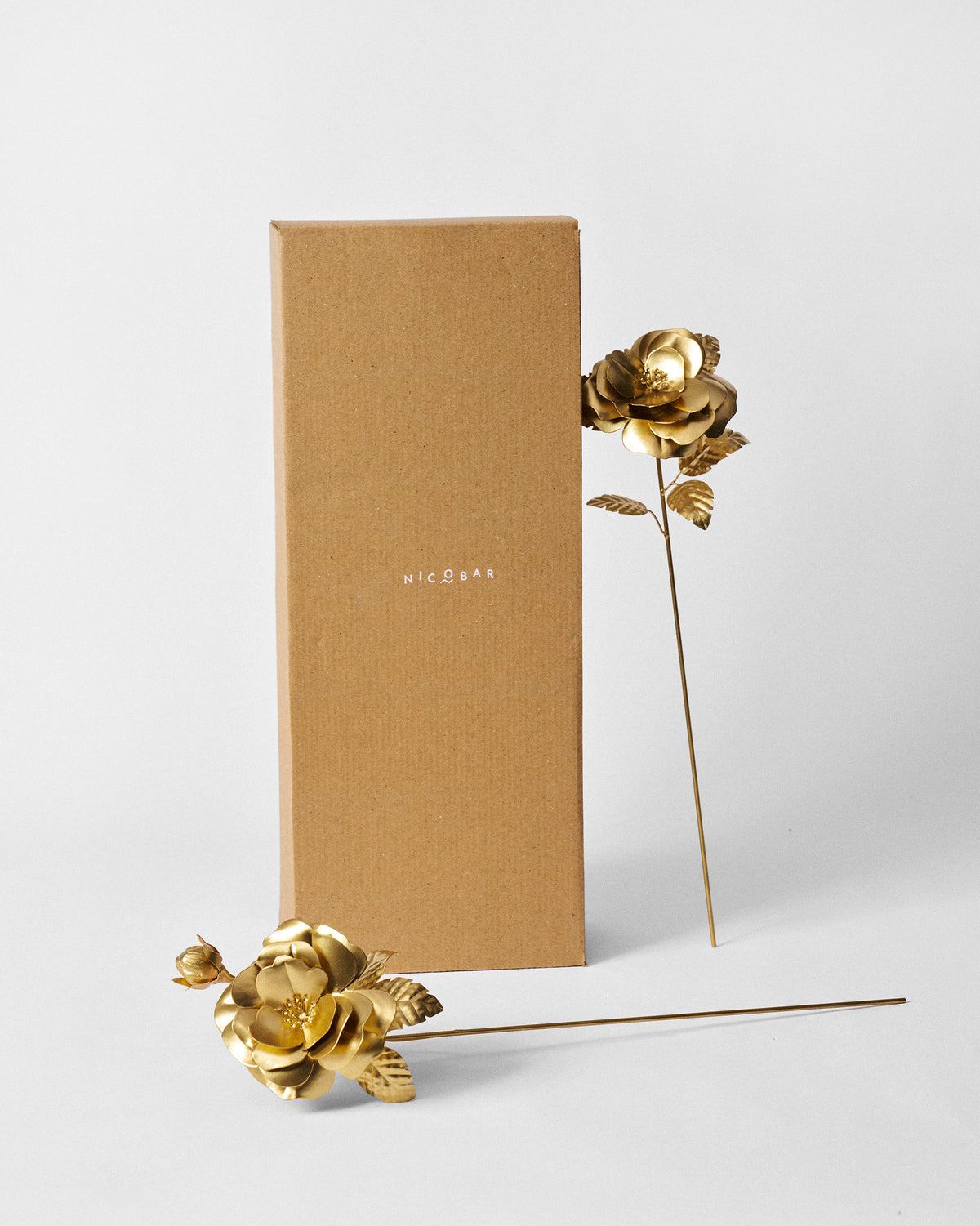 Gold rose home accents shown with a Nicobar kraft gift box.