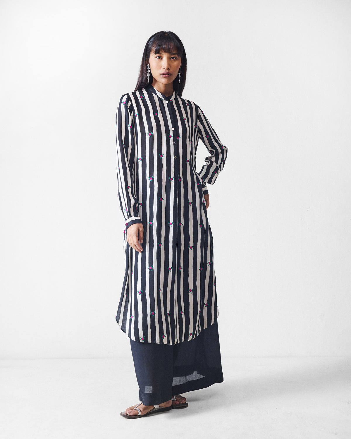 Three-quarter view of a black and beige striped long kurta with pink embroidery.