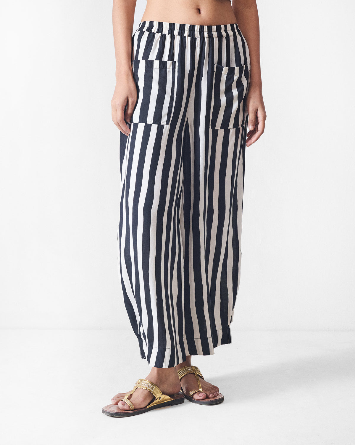 Person wearing black and beige striped Serene pants with patch pockets.