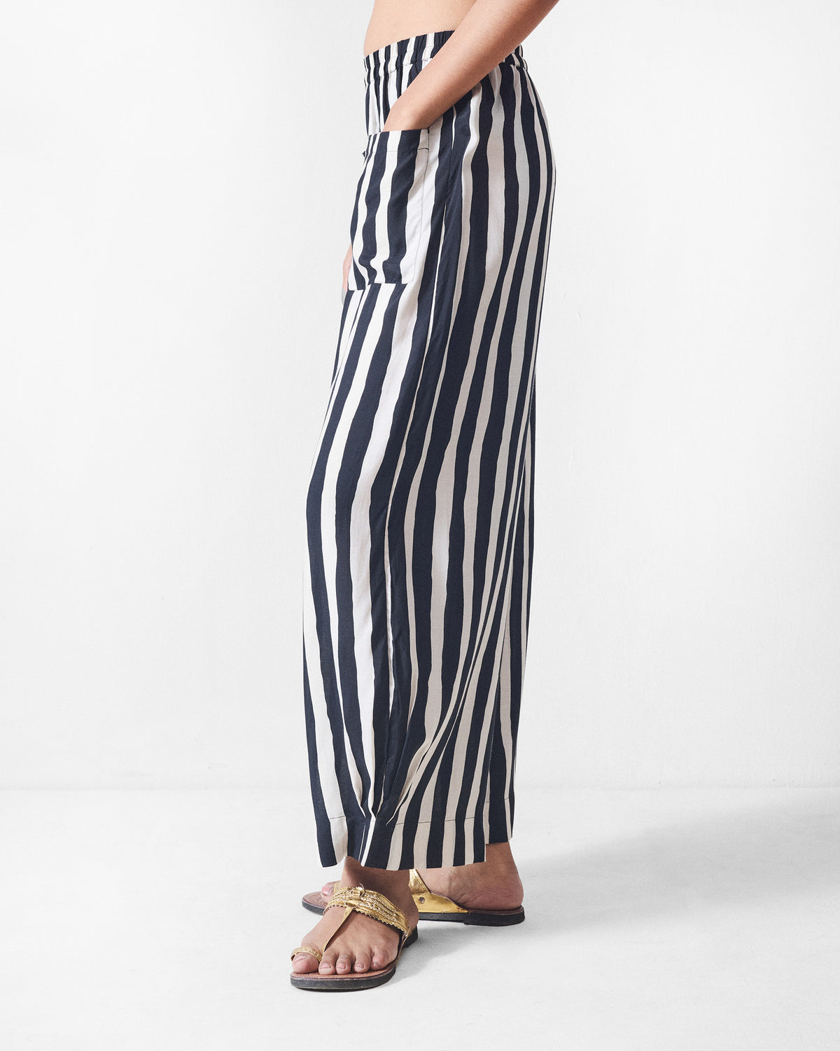 Side view of black and beige striped Serene pants with a wide leg.