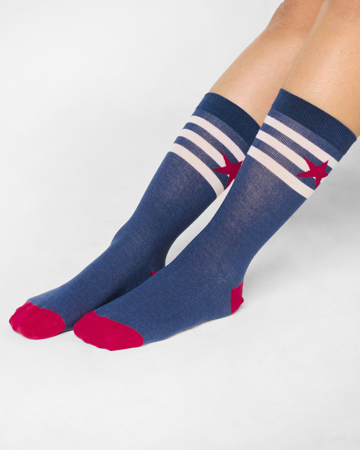 Side view of navy Starbed Socks with a red star and red toe.