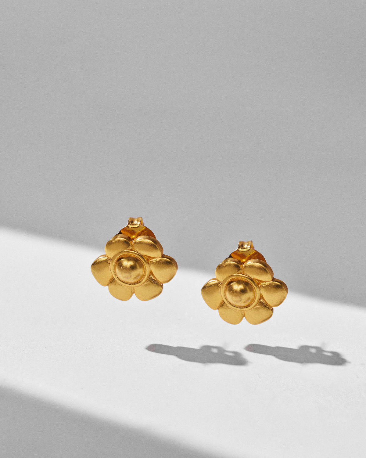 Pair of gold Daylily studs showing tiered petals and a raised centre.