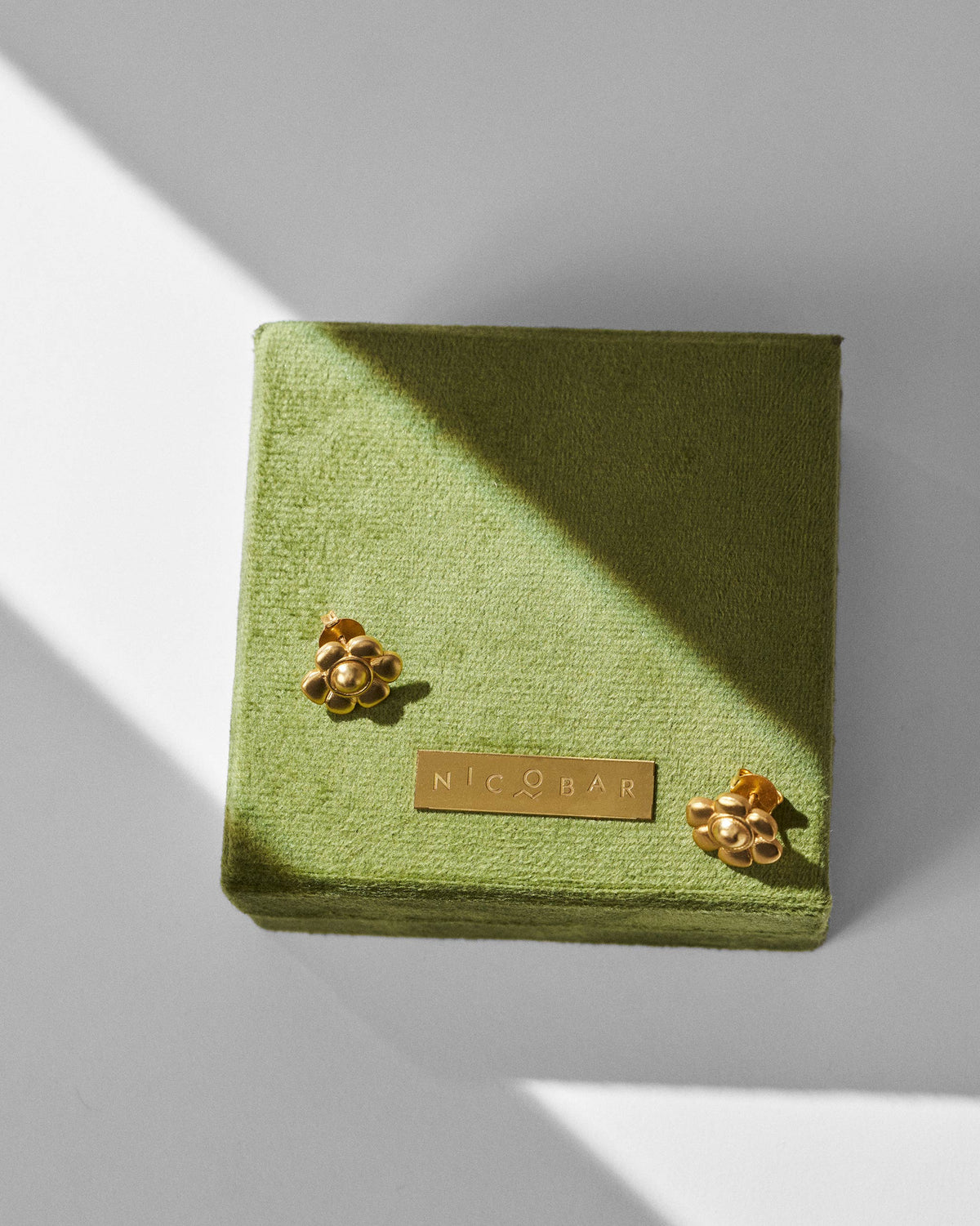 Gold Daylily flower studs on an olive green Nicobar gift box.