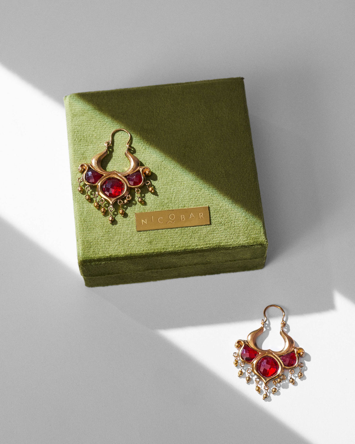 Antique gold Darbaar Balis with red glass on an olive green Nicobar gift box.