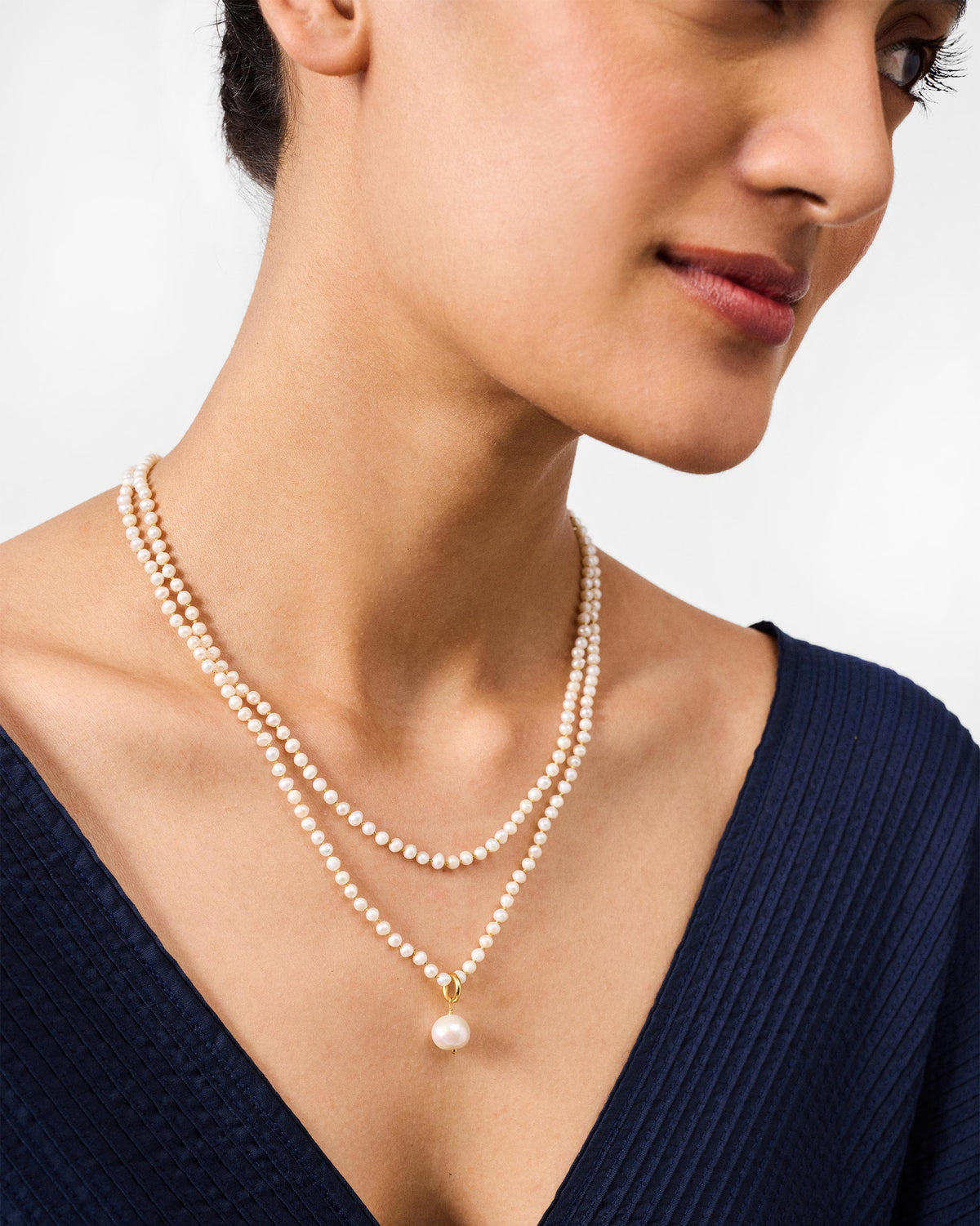 Person wearing a double-strand Chandni pearl necklace with a centre pearl drop.