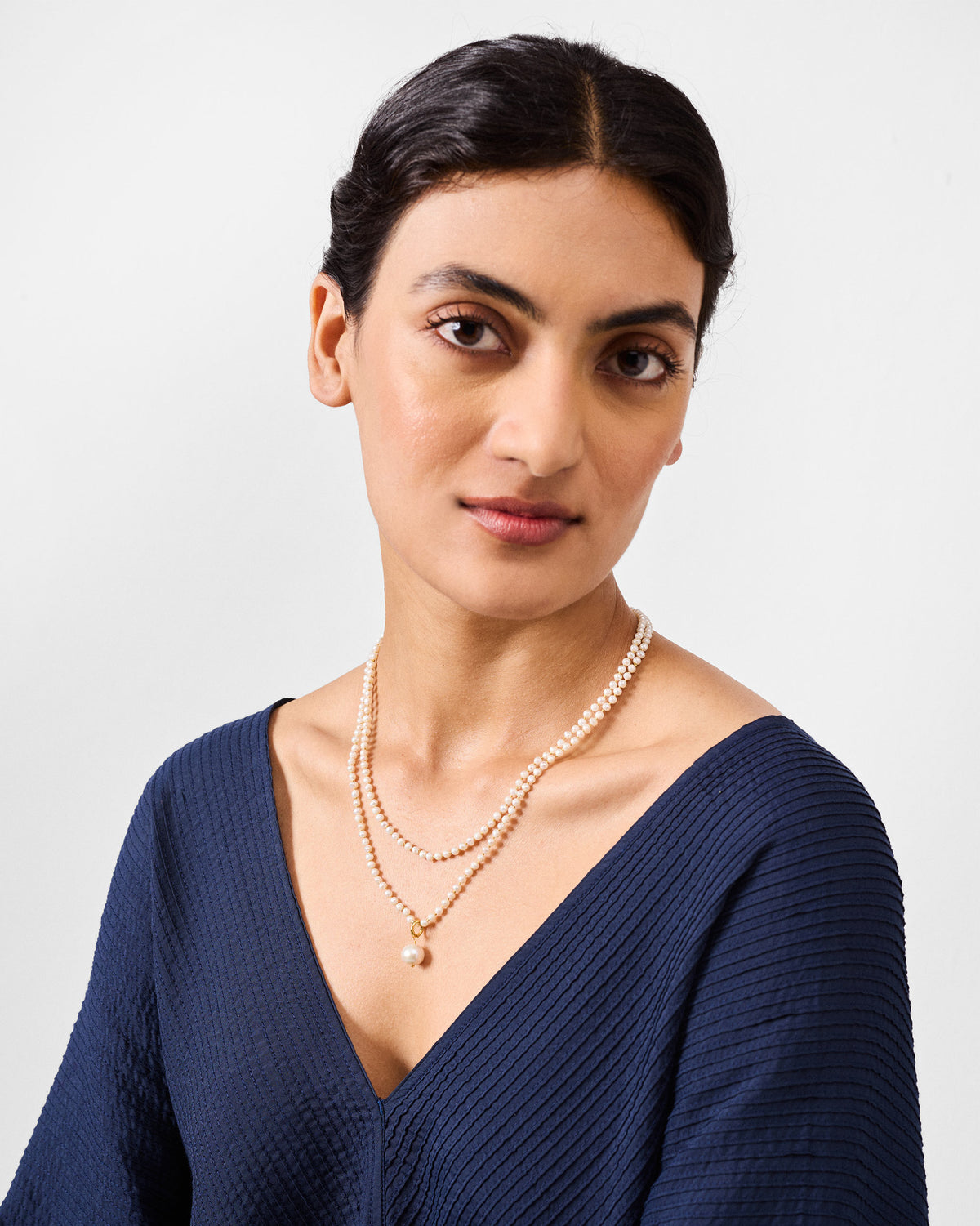 Person wearing a double-strand Chandni pearl necklace.