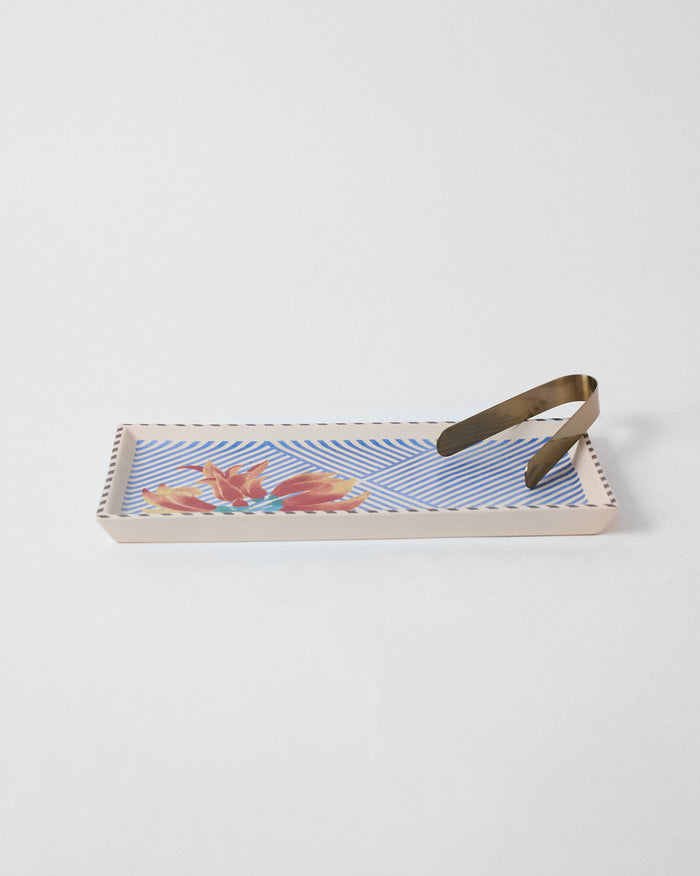 Palash cookie tray with blue stripes and orange flower print, brass tongs on top.