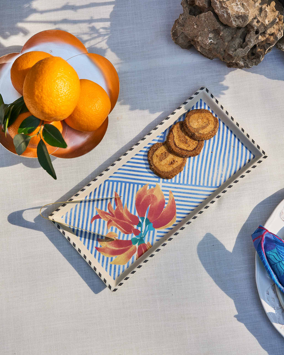 Palash cookie tray with orange flower print holding swirl cookies.