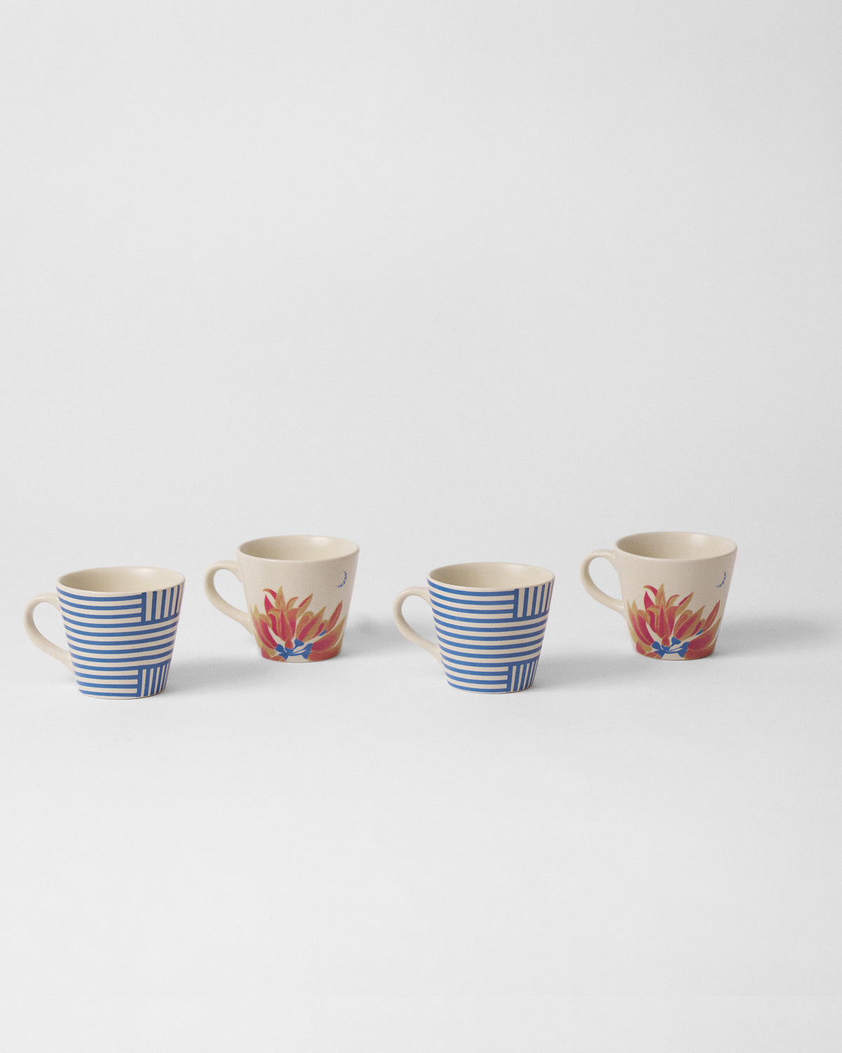Four Koel espresso mugs in a row alternating blue stripes and palash blooms.