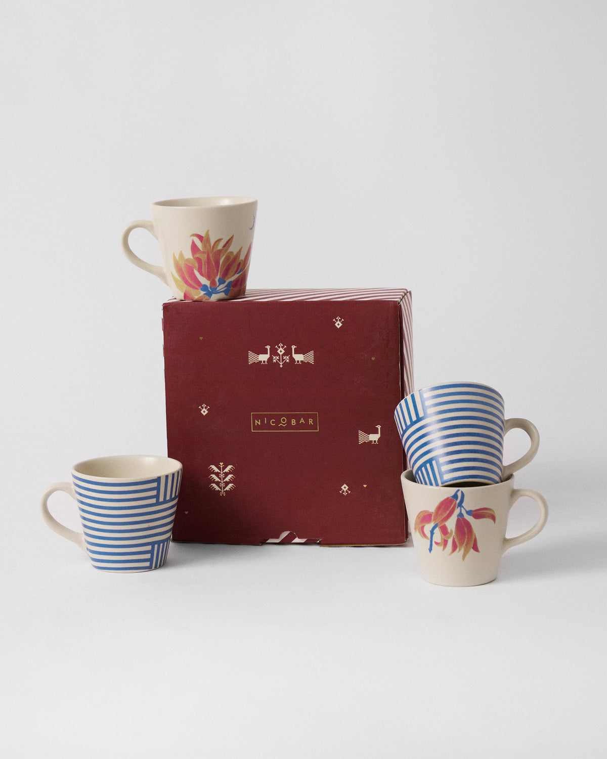 Koel espresso mug set of four with gift box showing striped and floral designs.