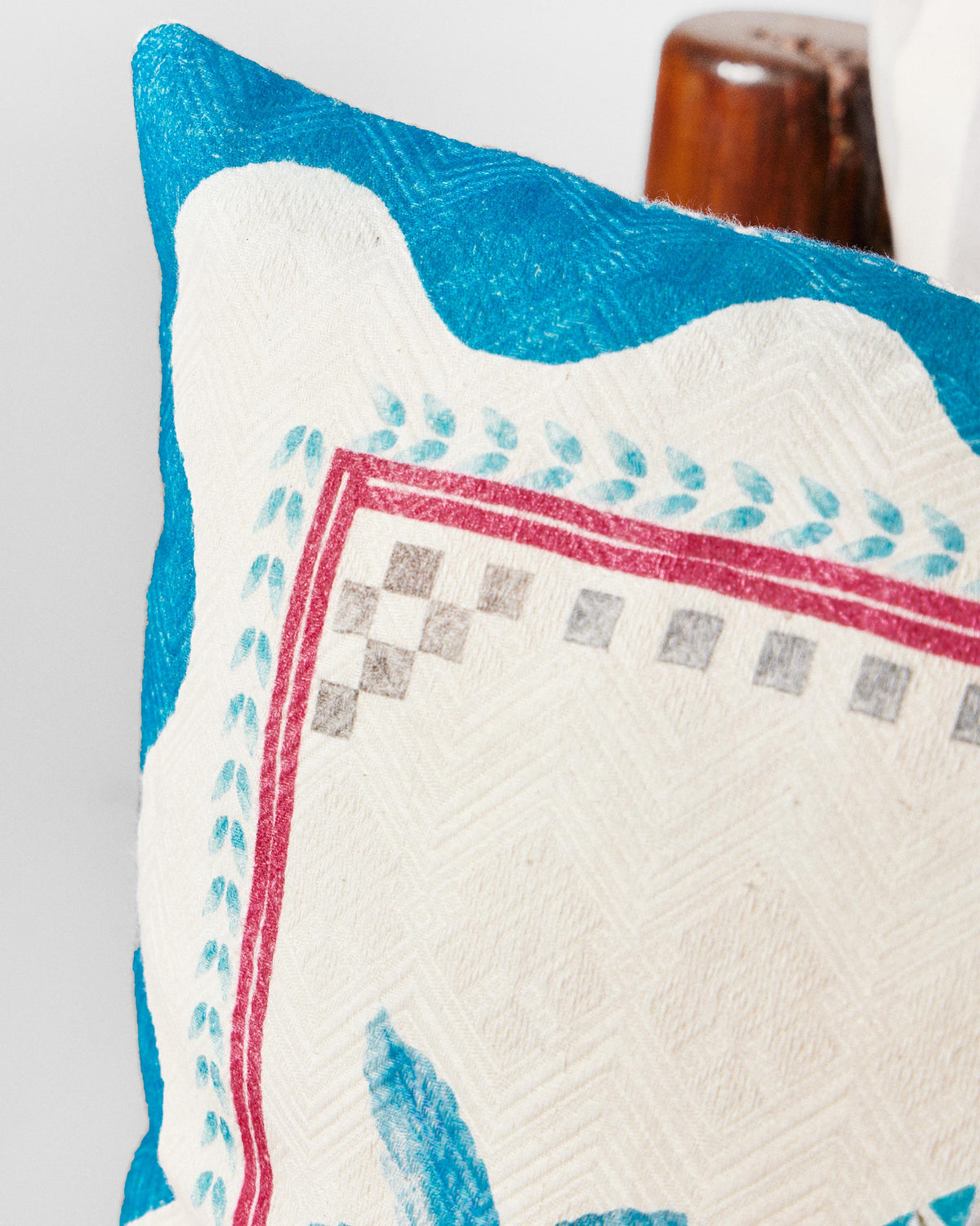Close-up of Blue Scallop cushion cover corner with a red-edged frame.