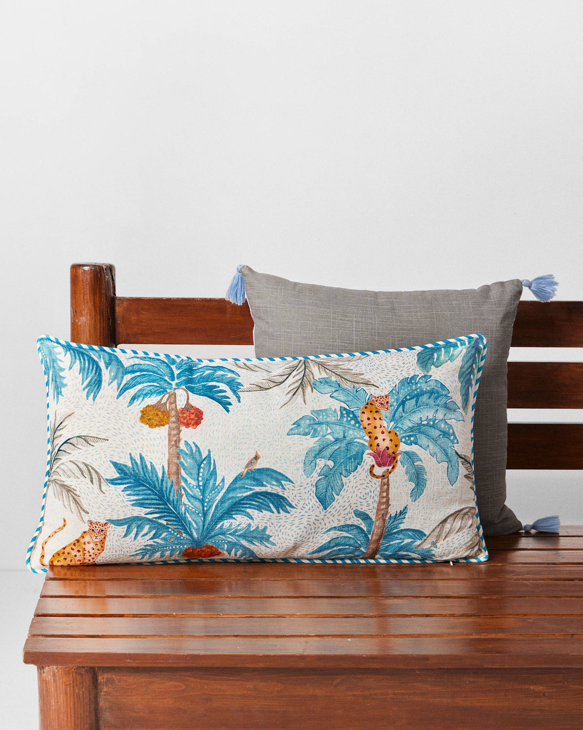 Sindhuraa cushion cover in cream with teal palms and leopards.