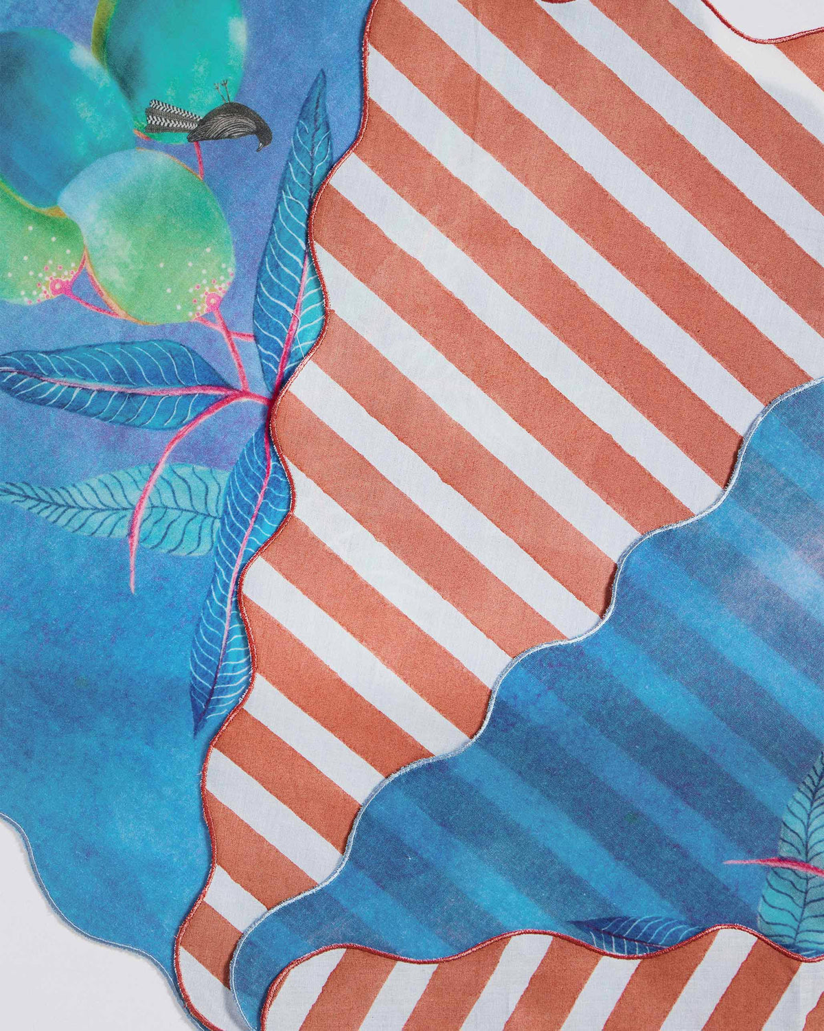 Close-up of the Ambi Dining Napkin showing its blue fruit and bird print and orange stripes.