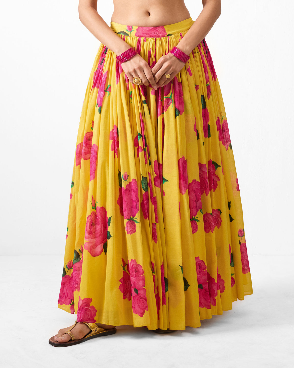 Person wearing a yellow Reha skirt with a pink rose print.