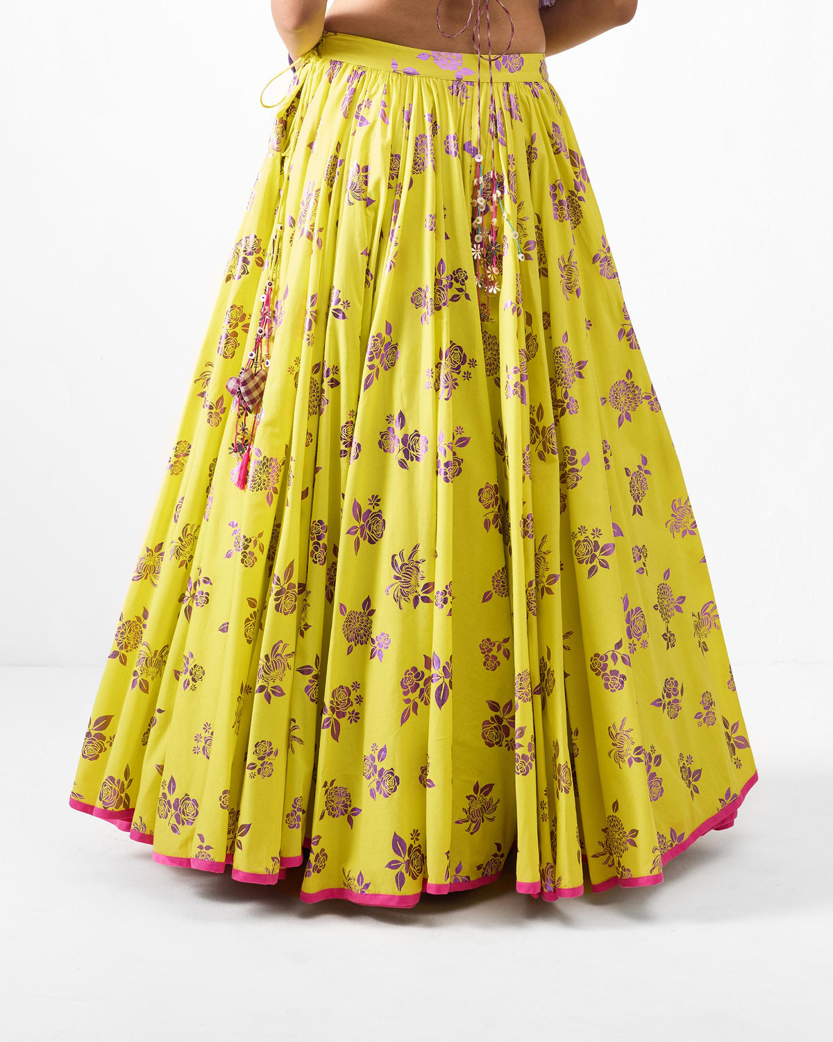 Back of a lime Noor skirt with purple foil florals and a pink hem.
