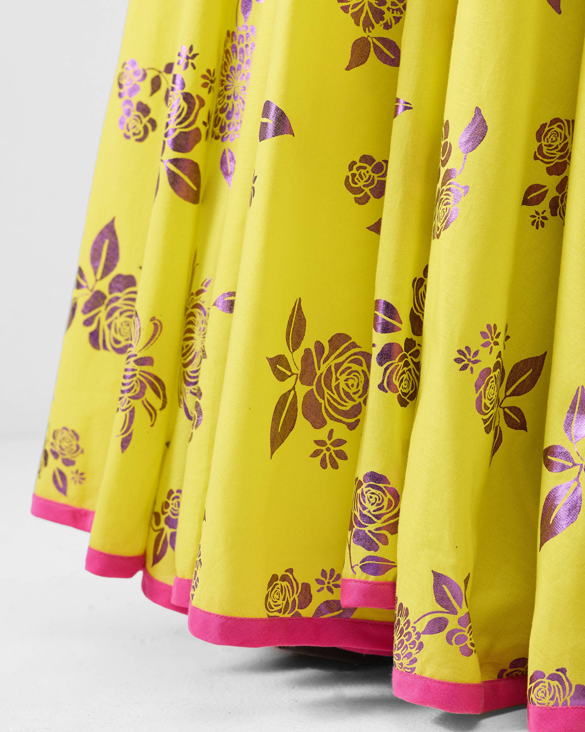 Close-up of purple foil florals and pink hem on a lime Noor skirt.