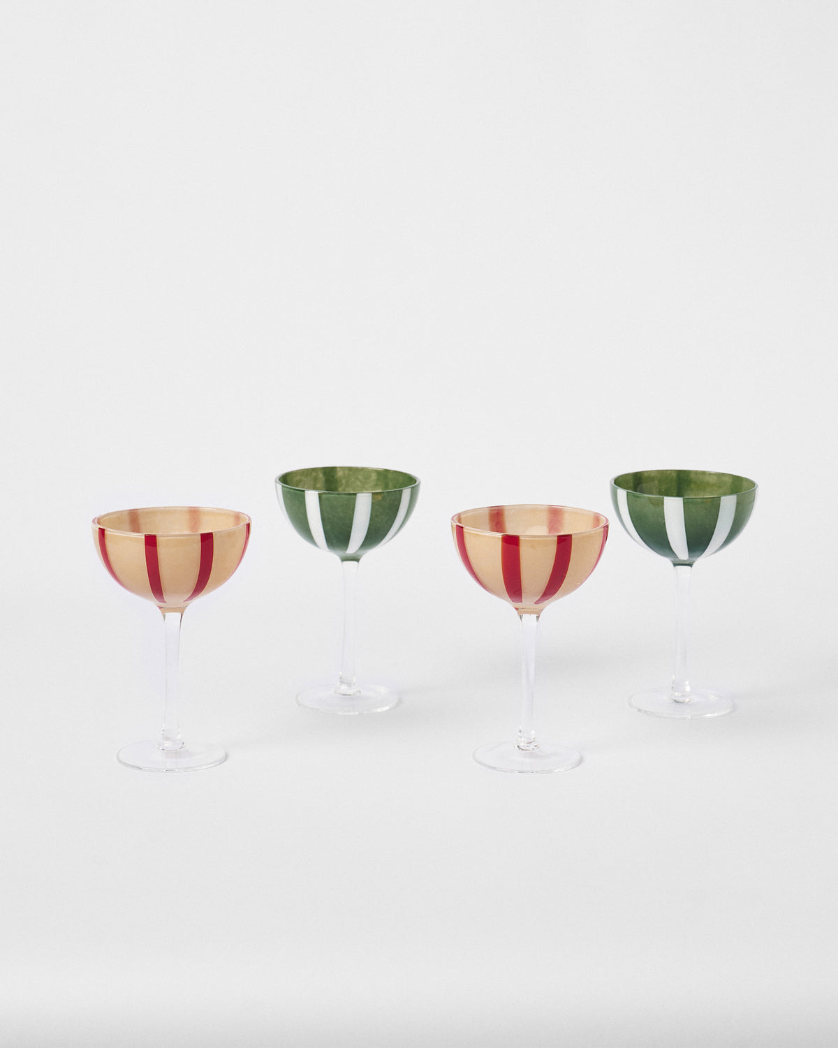 Four Lune cocktail glasses set at staggered positions, showing their stripes.