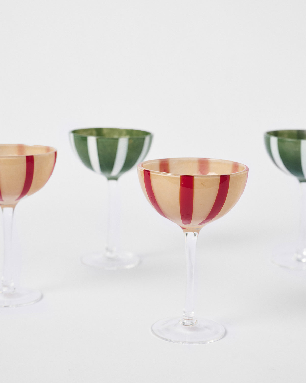 Close-up of Lune cocktail glasses with bold red and green bowl stripes.