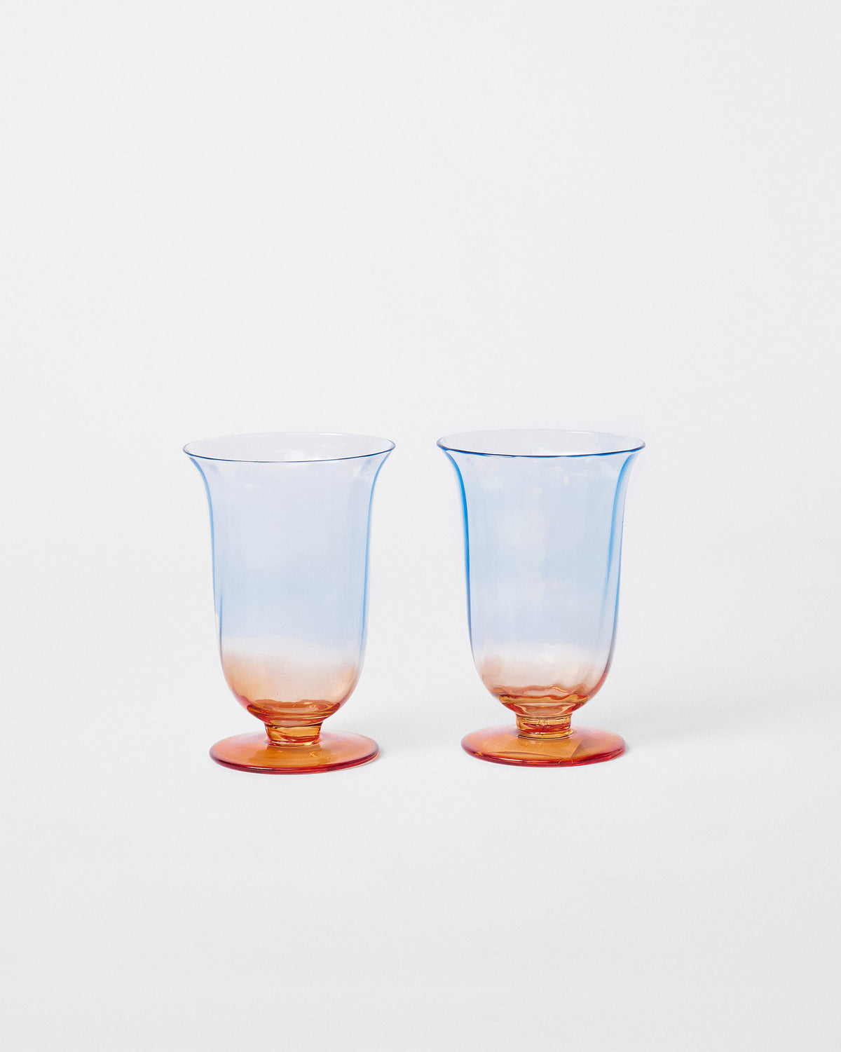 Pair of Oro cocktail glasses with pale blue to amber ombre bowls.