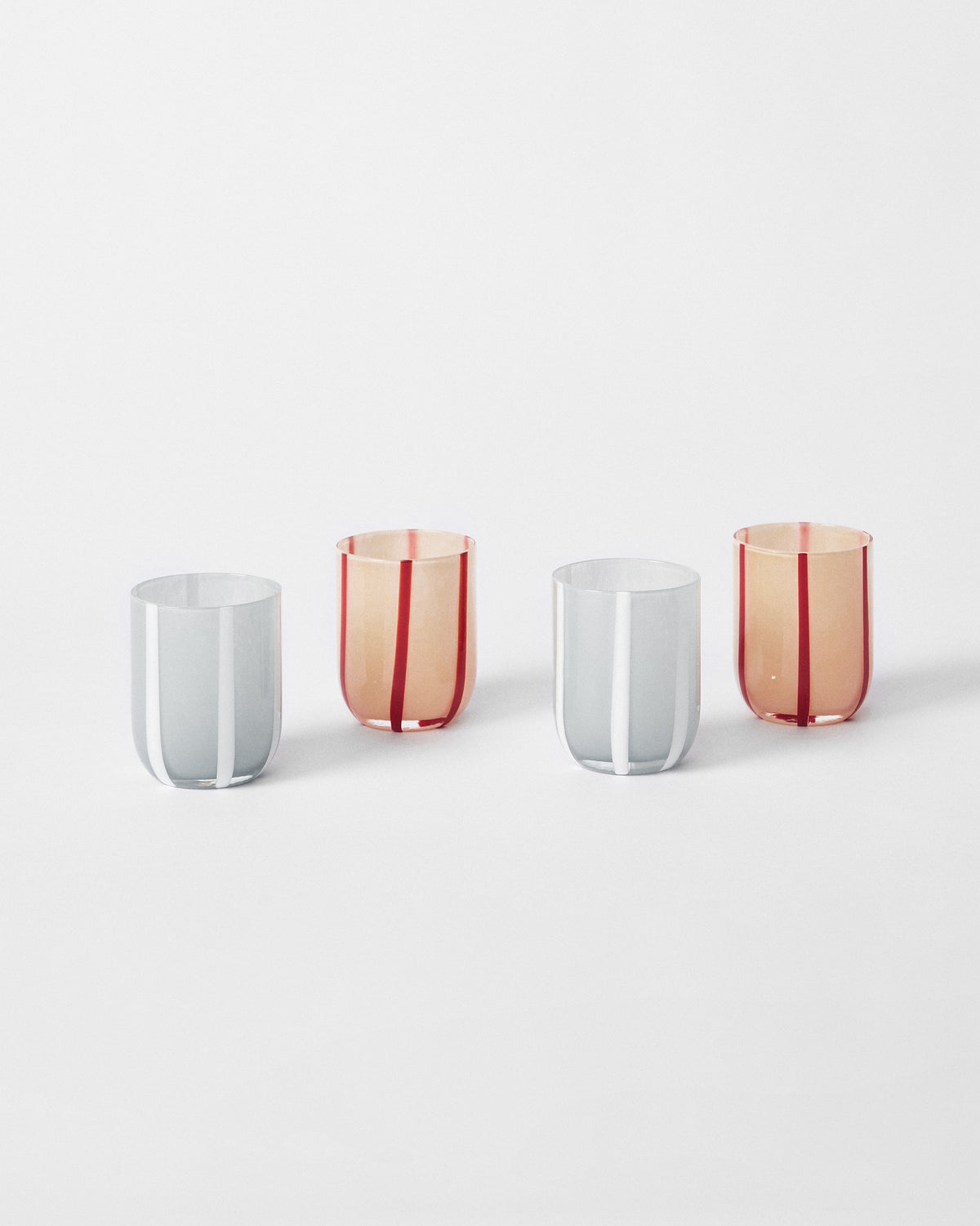 Four Demi striped glasses staggered in peach and grey colourways.