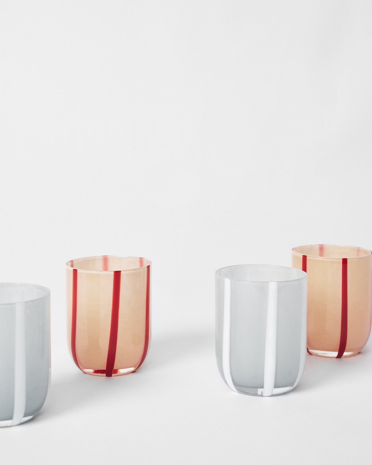 Demi drinking glasses showing bold vertical stripes in two colourways.