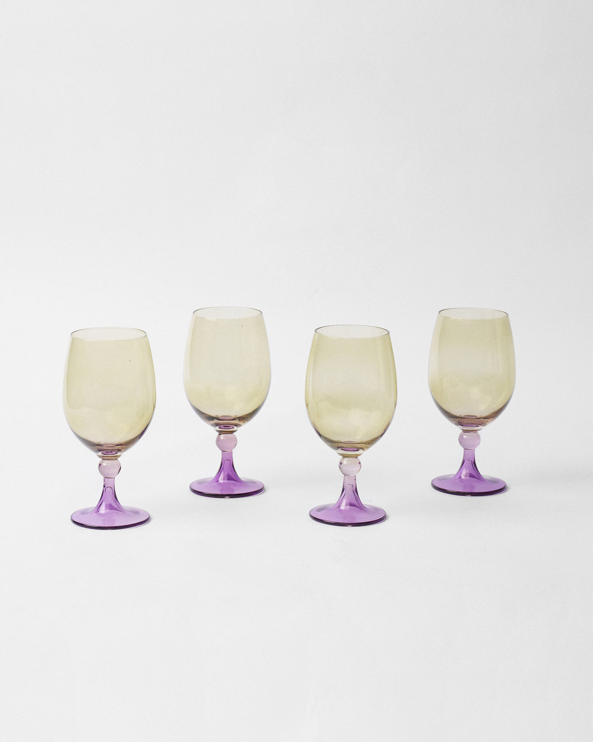 Cairo gin goblets showing amber bowls against vivid purple stems and bases.