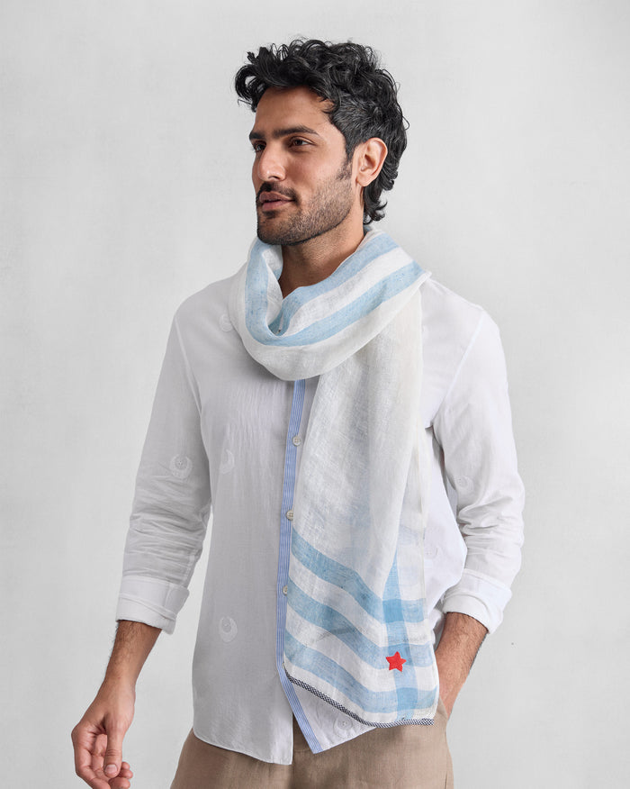 Person wearing a white Summer Breeze scarf with pale blue stripes and a red star.