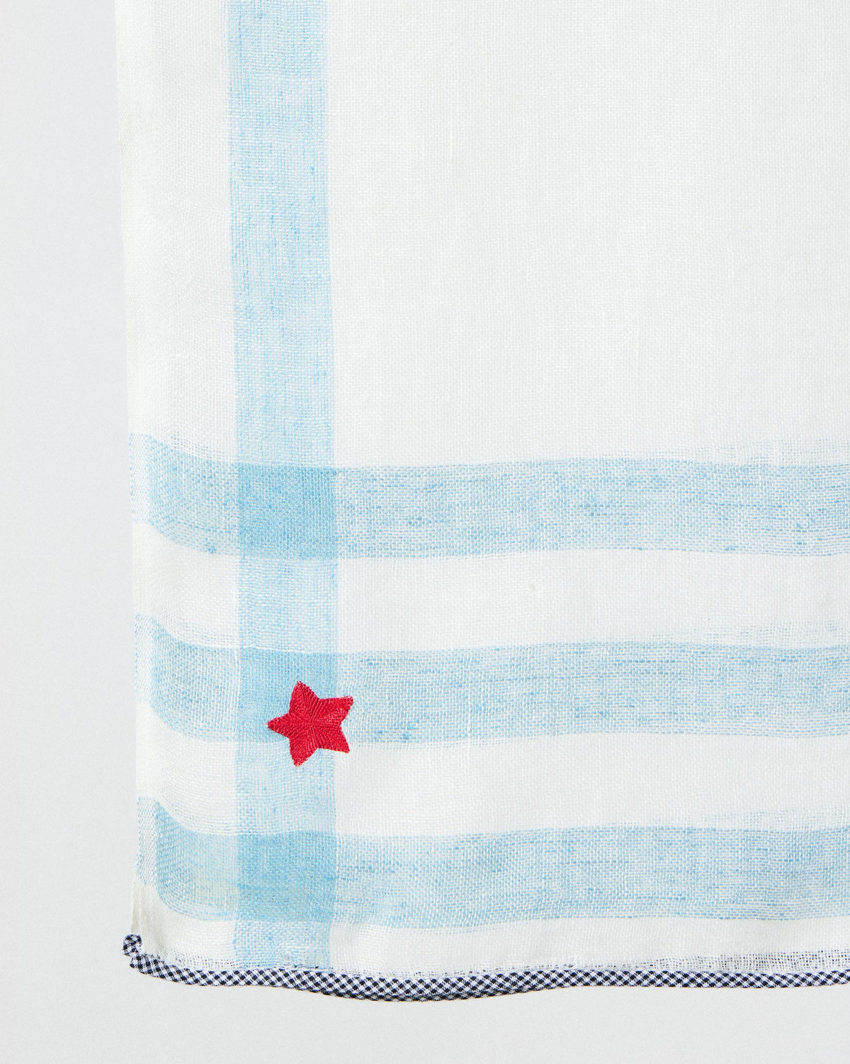 Close-up of Summer Breeze scarf corner showing blue stripes and a red star.