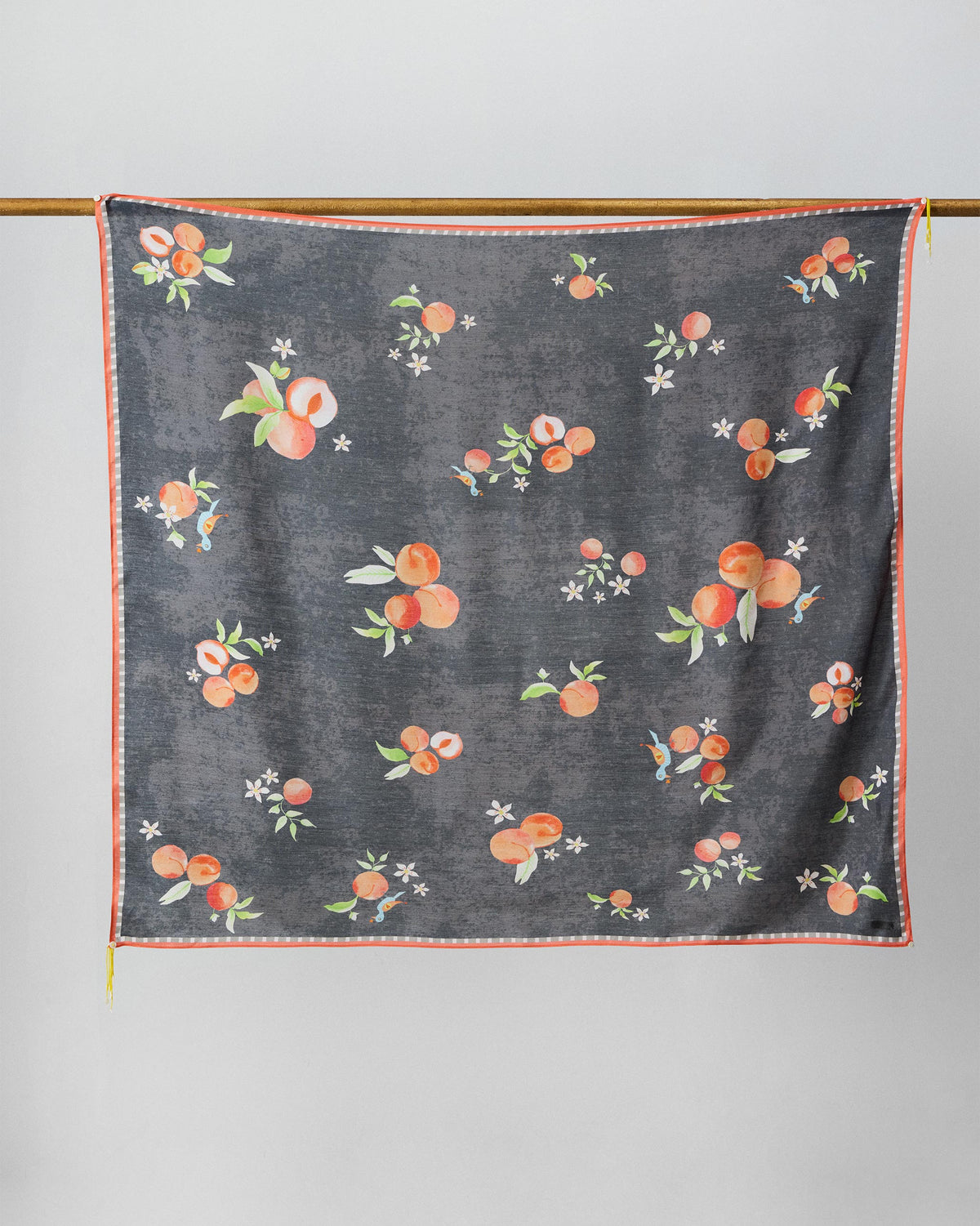 Charcoal Apricot Scarf with peach and blossom print hanging flat.