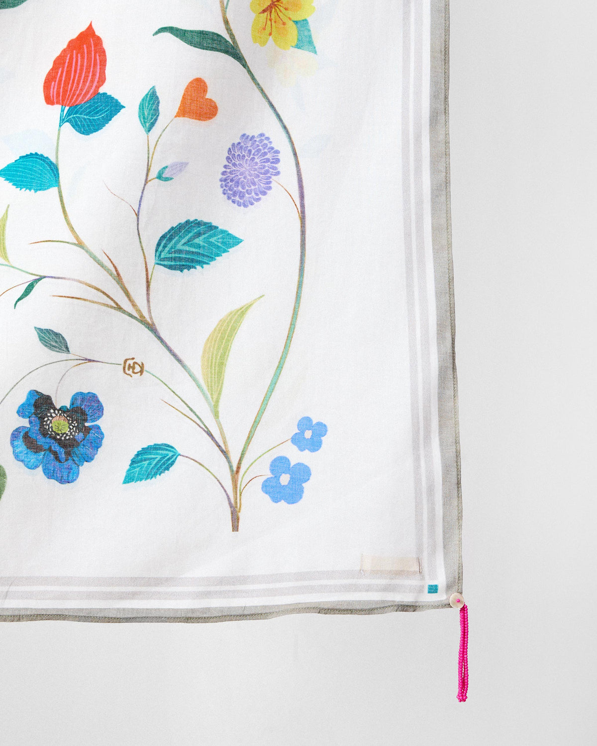 Close-up of the Jaal Scarf's corner with a pink beaded tassel.