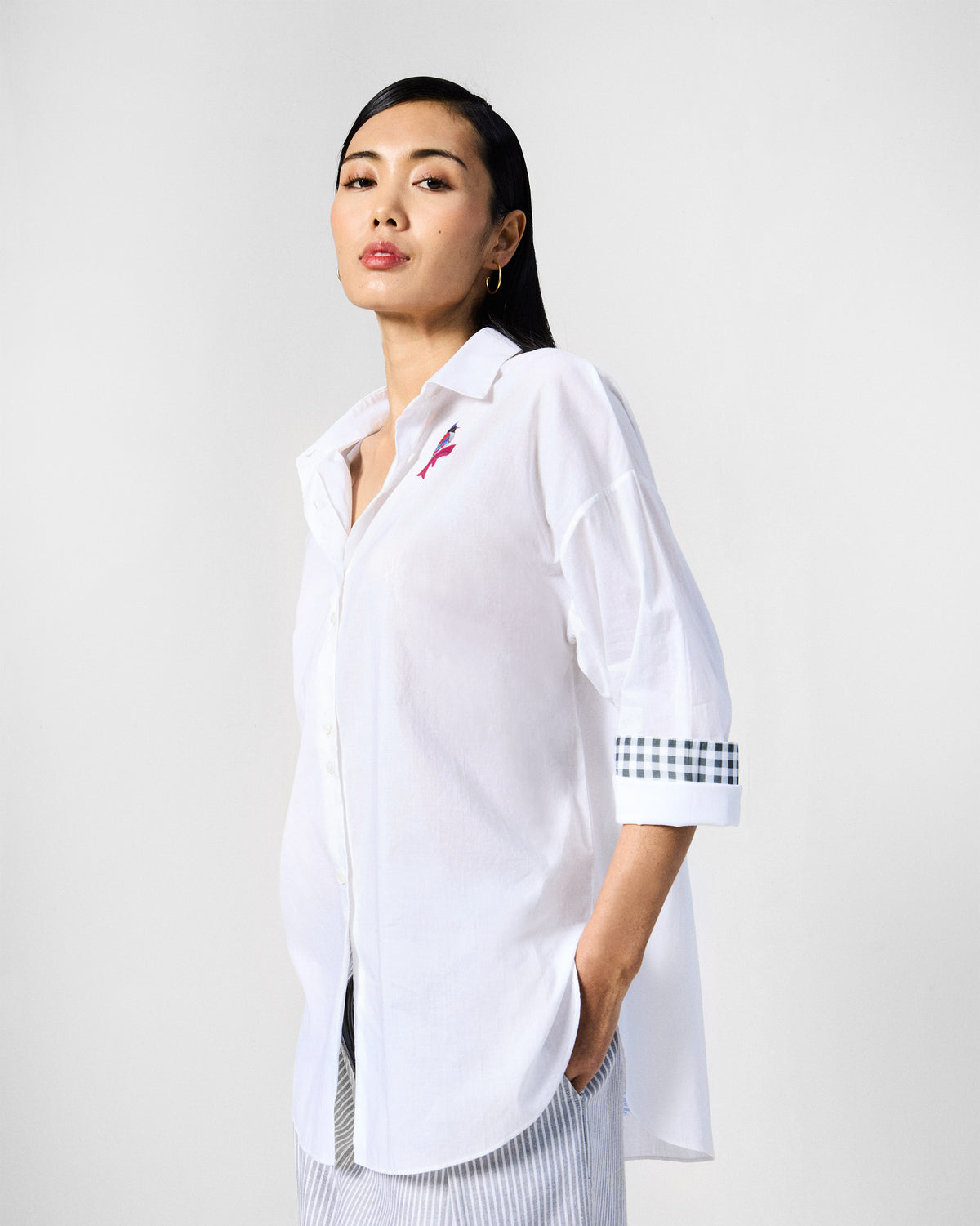 Person wearing a white Siv shirt with check cuffs rolled up.