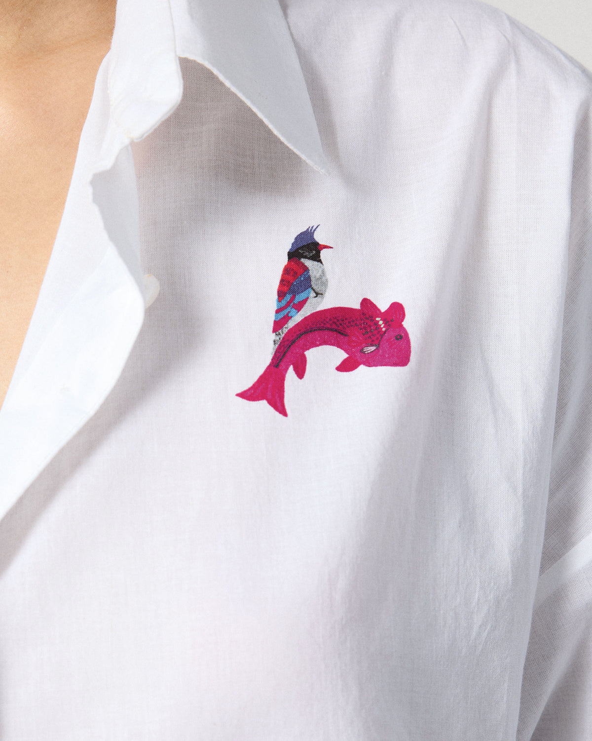 Close-up of a bird and fish print on a white Siv shirt.