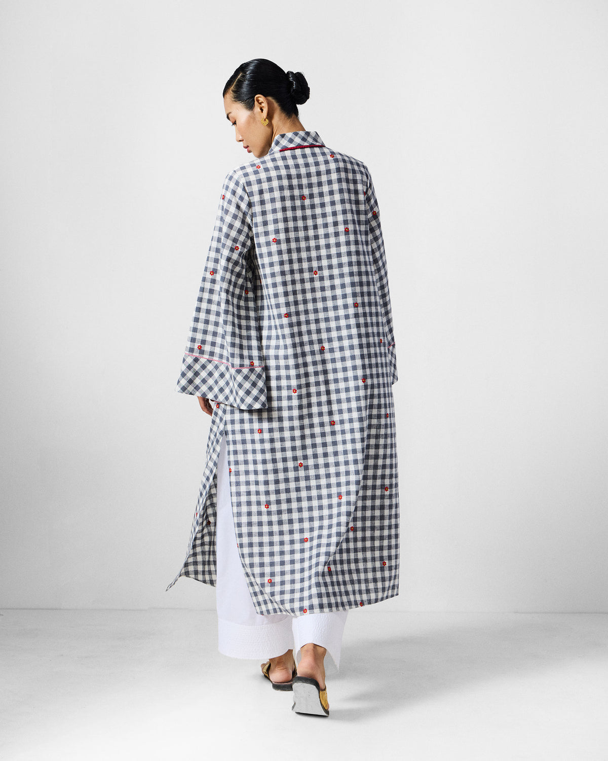 Back of a navy check Dhauli Kurta with red floral embroidery and side slits.