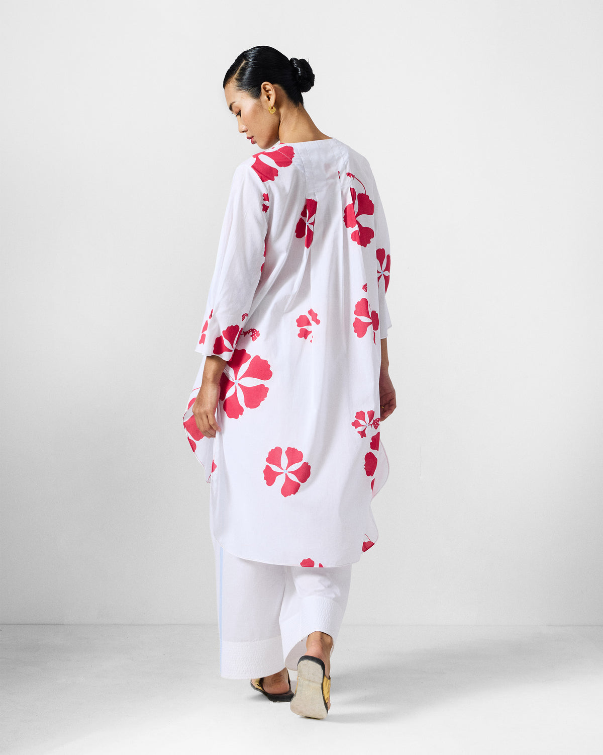 Back of a white and red printed Pampa kurta showing the gathered yoke and flowing length.