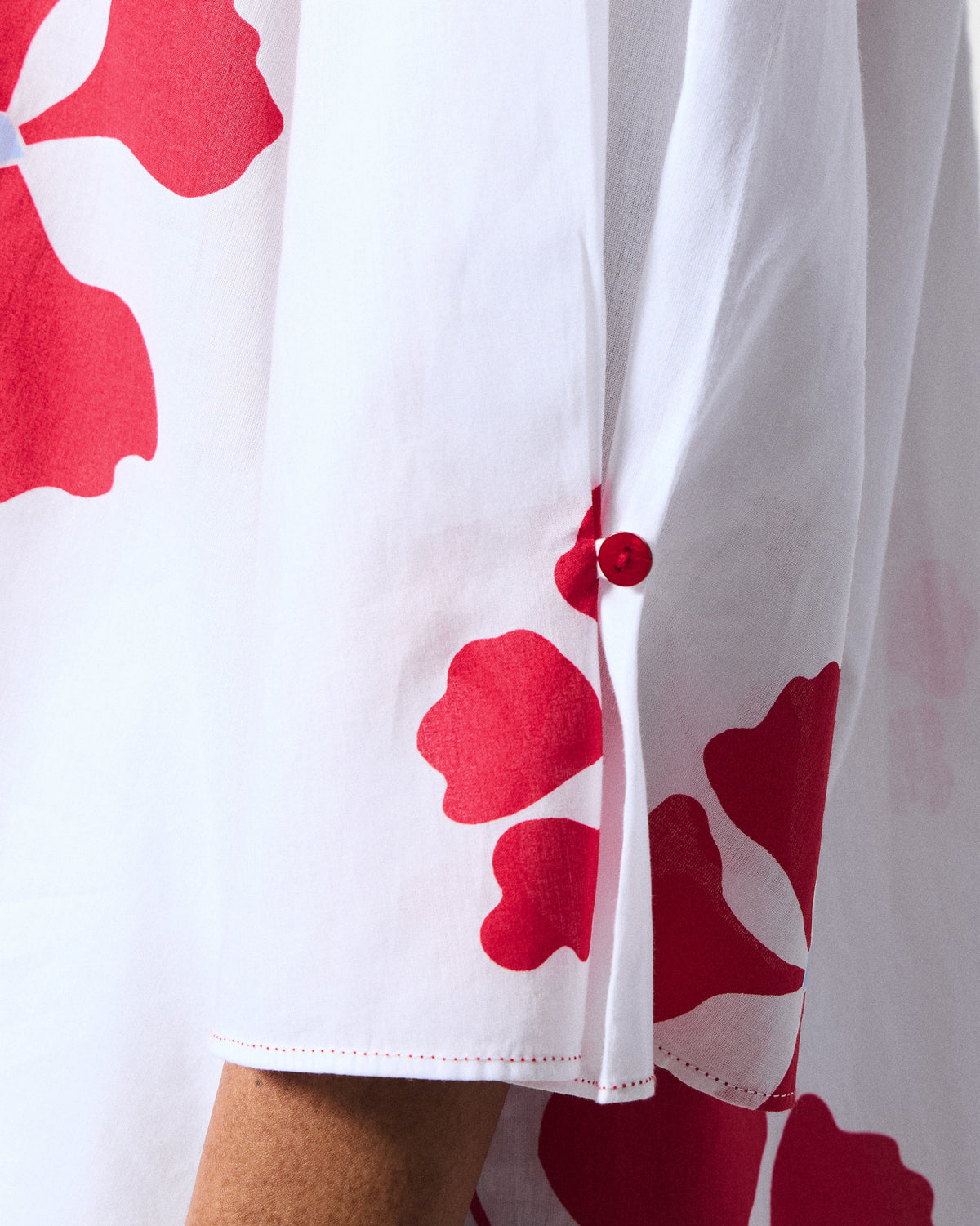 Close-up of the sleeve cuff and red floral print on a white and red Pampa kurta.