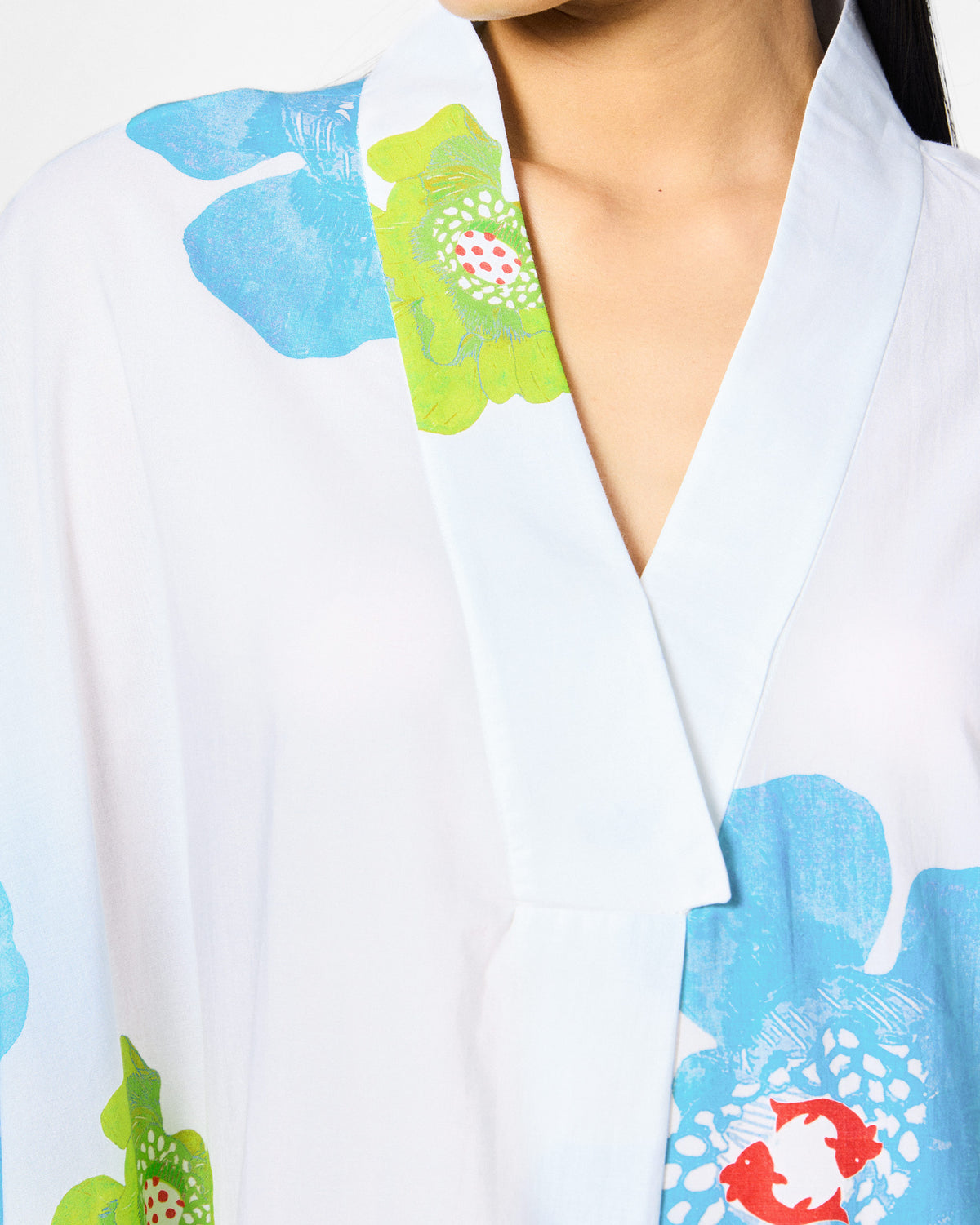 Close-up of the V-neck on a white Bea kaftan with blue and lime florals.