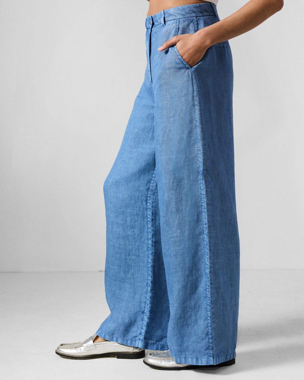 Side view of blue wide-leg Aven pants showing the straight wide silhouette.