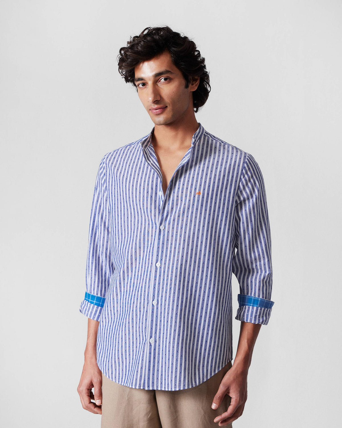 Person wearing a navy and white striped Nawab shirt with an orange chest logo.