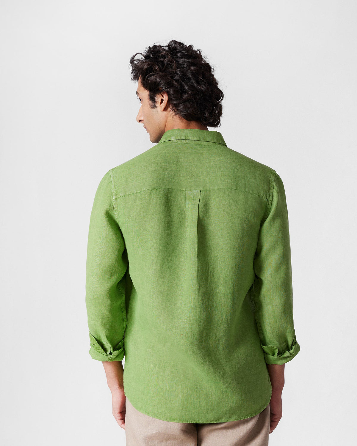 Back of a dark green Classic Shirt with a box pleat.