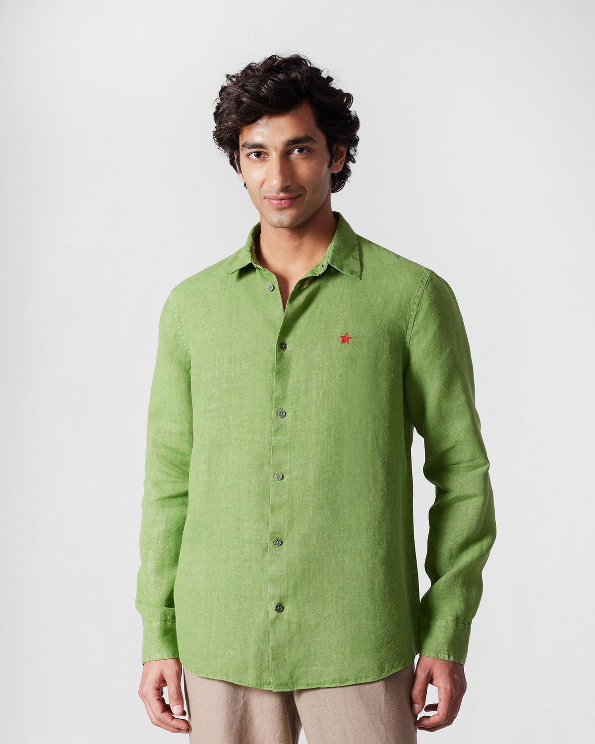 Person wearing a dark green Classic Shirt with a red embroidered star.