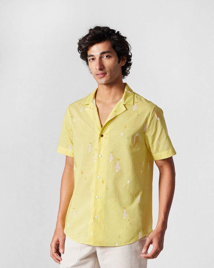 Person wearing a light yellow Mistari Shirt with a scattered white fish print.