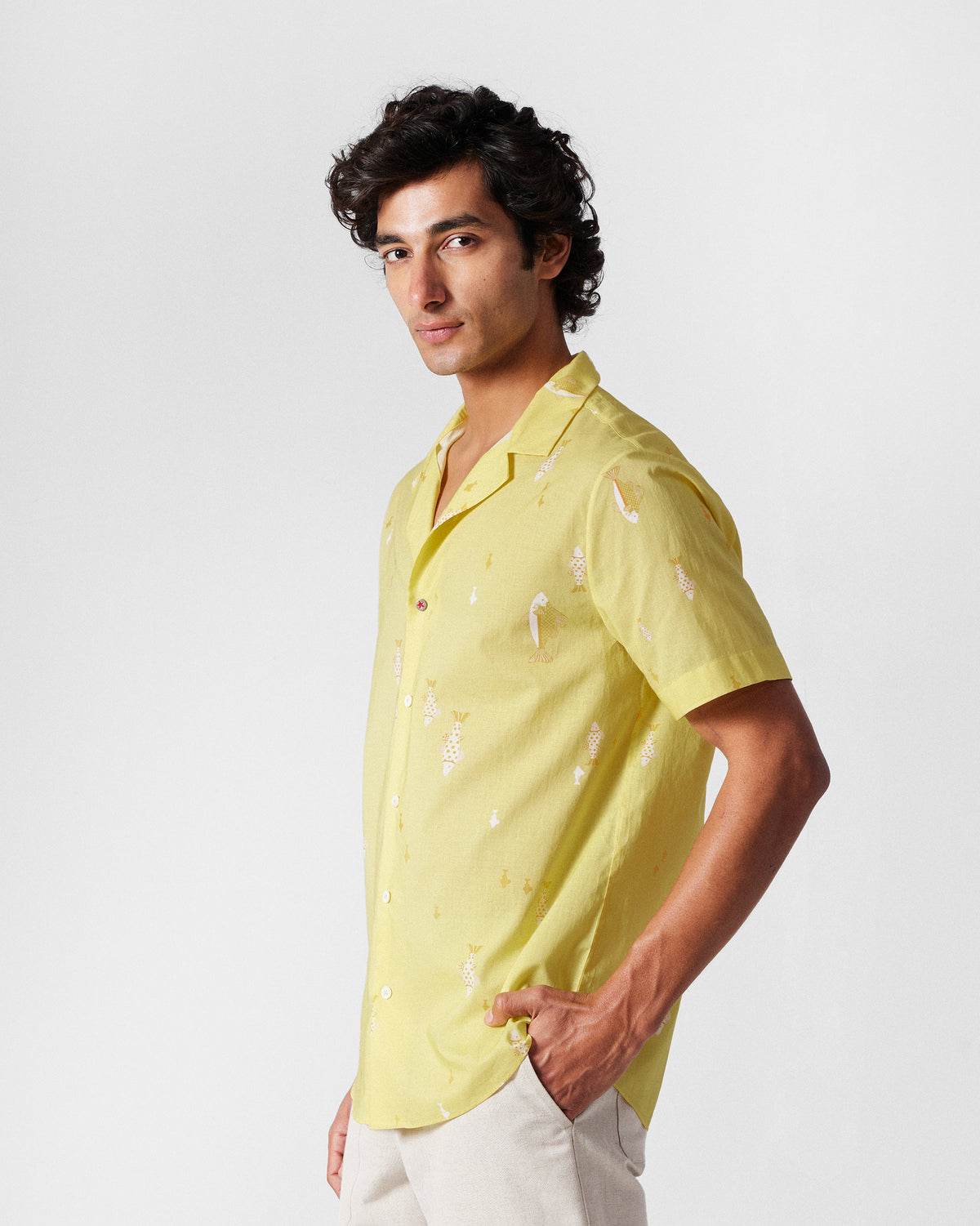 Three-quarter view of a light yellow Mistari Shirt with a fish print.