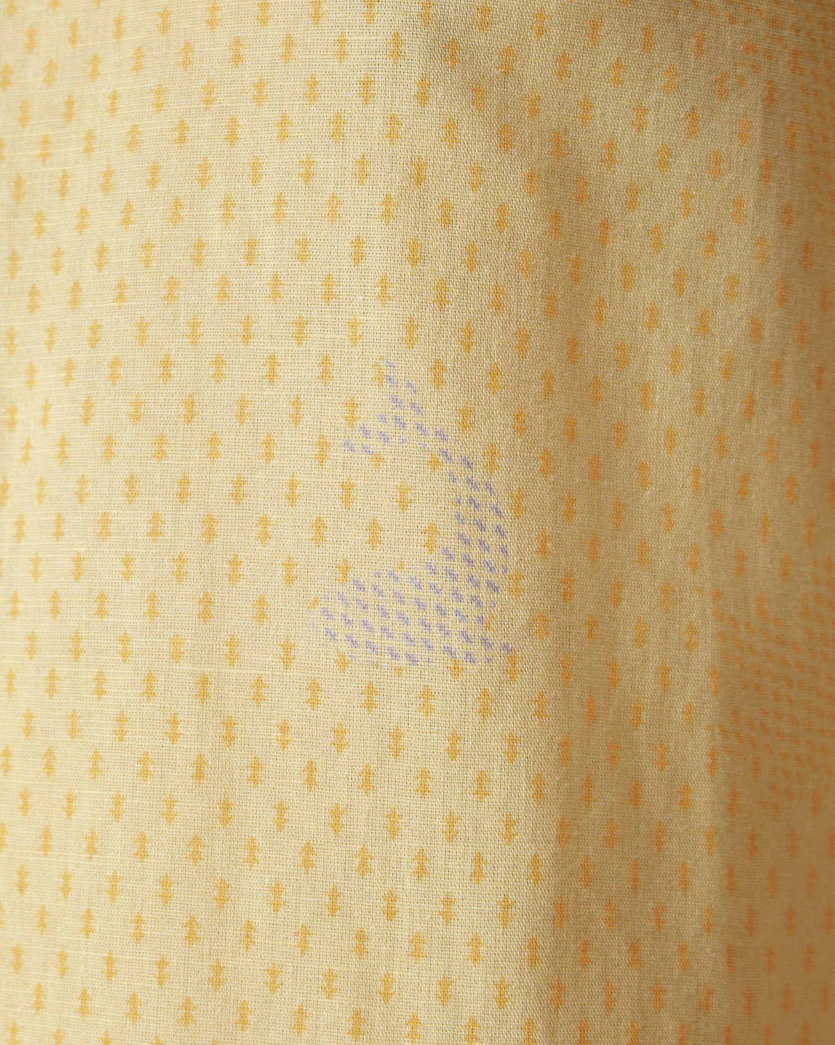 Close-up of a light yellow Astral kurta showing micro print and a bird motif.