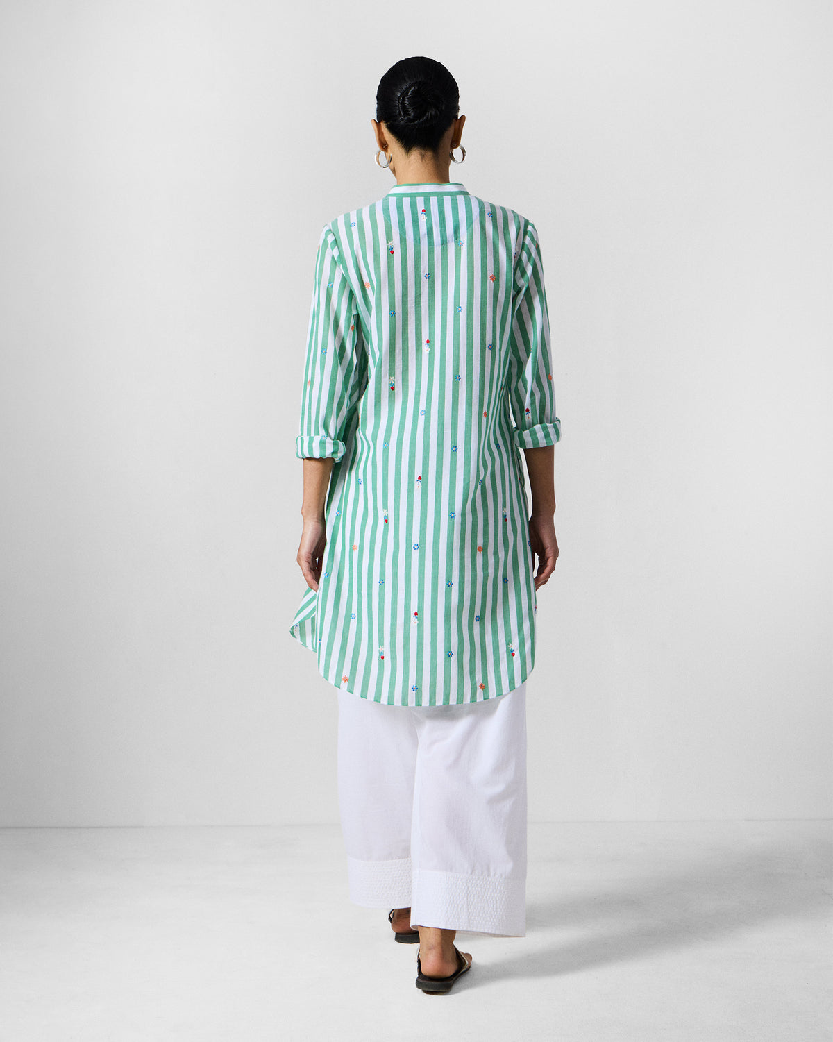 Back of a green and white striped mid-length kurta with floral embroidery.