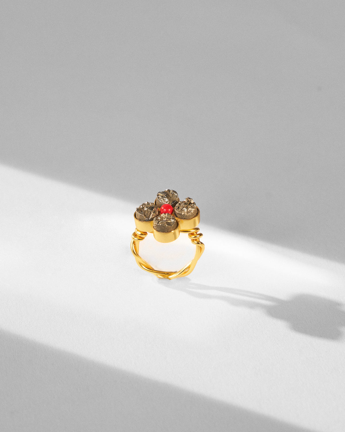 Sindhu gold flower ring standing to show its twisted band.