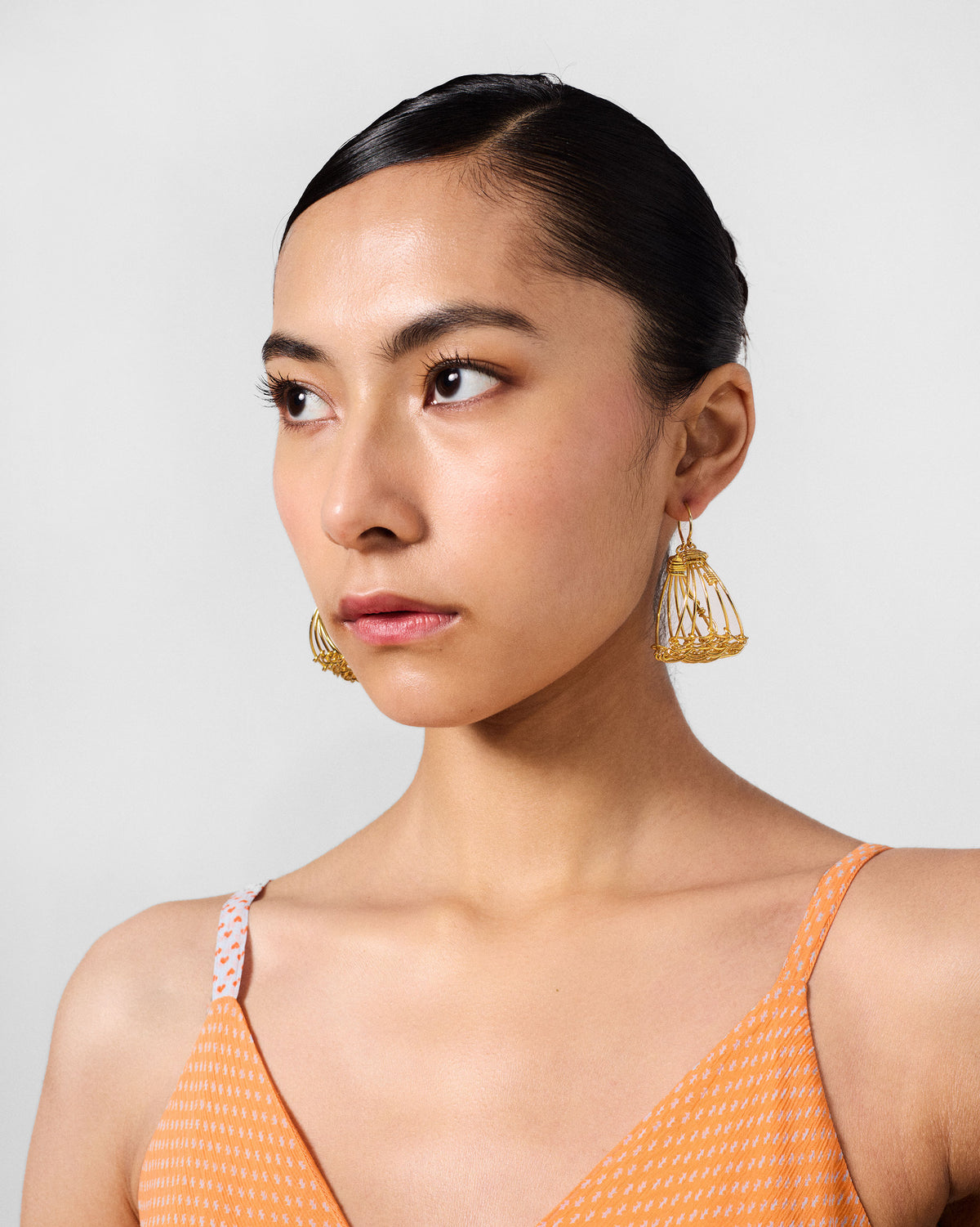 Person wearing gold Shore wire cage balis.