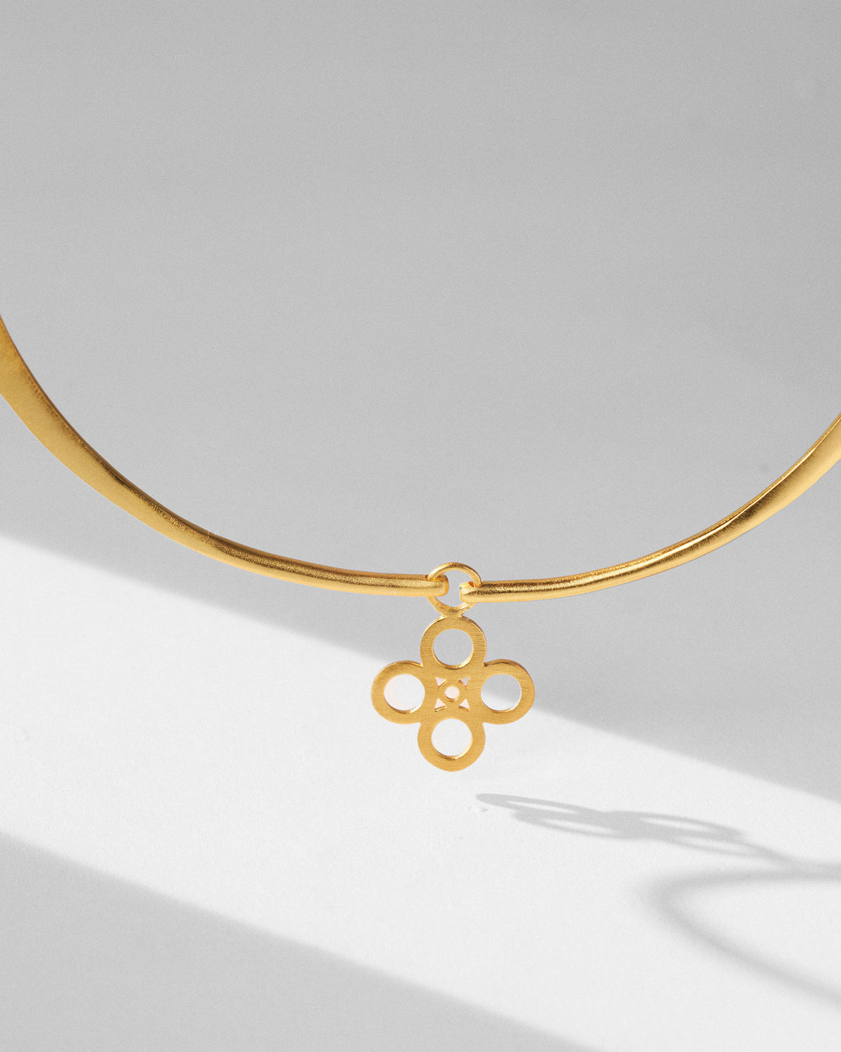 Close-up of a gold sindhu choker pendant with a floral motif.